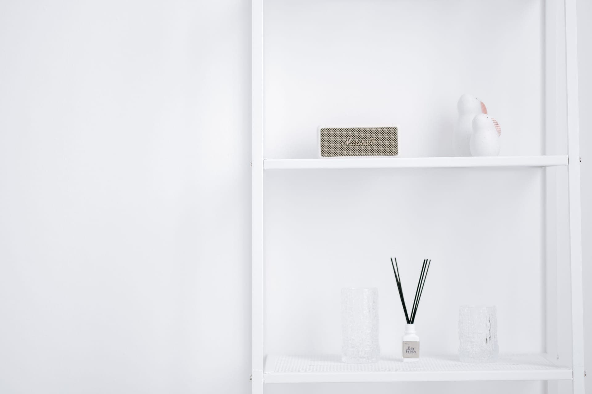 A plain white shelf holding a few carefully chosen objects