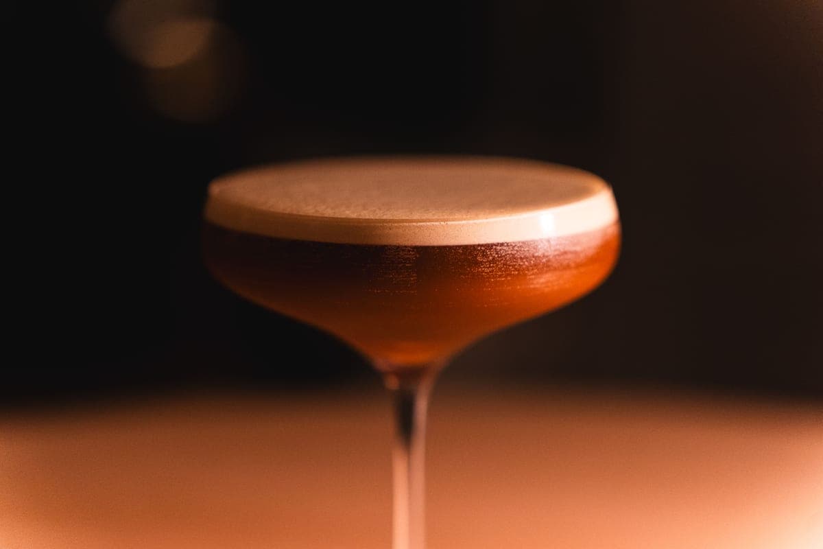 A set of coupe cocktail glasses standing together on a light surface