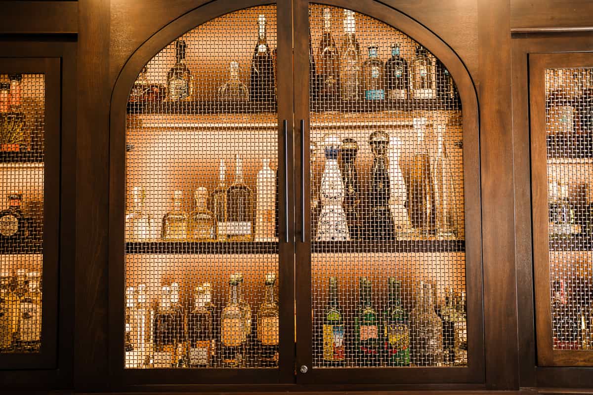 A wooden cabinet with closed doors standing against a wall in a living room