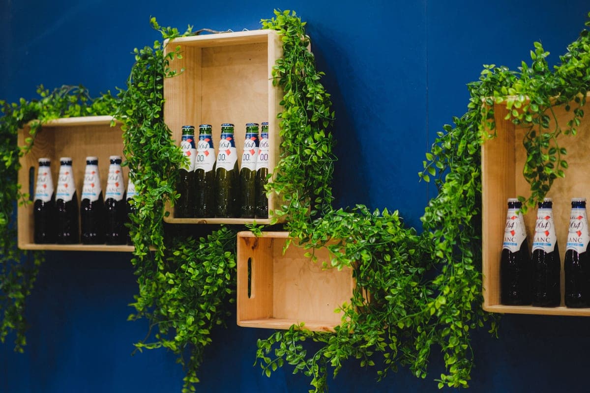 Two floating wall shelves holding bottles and glassware