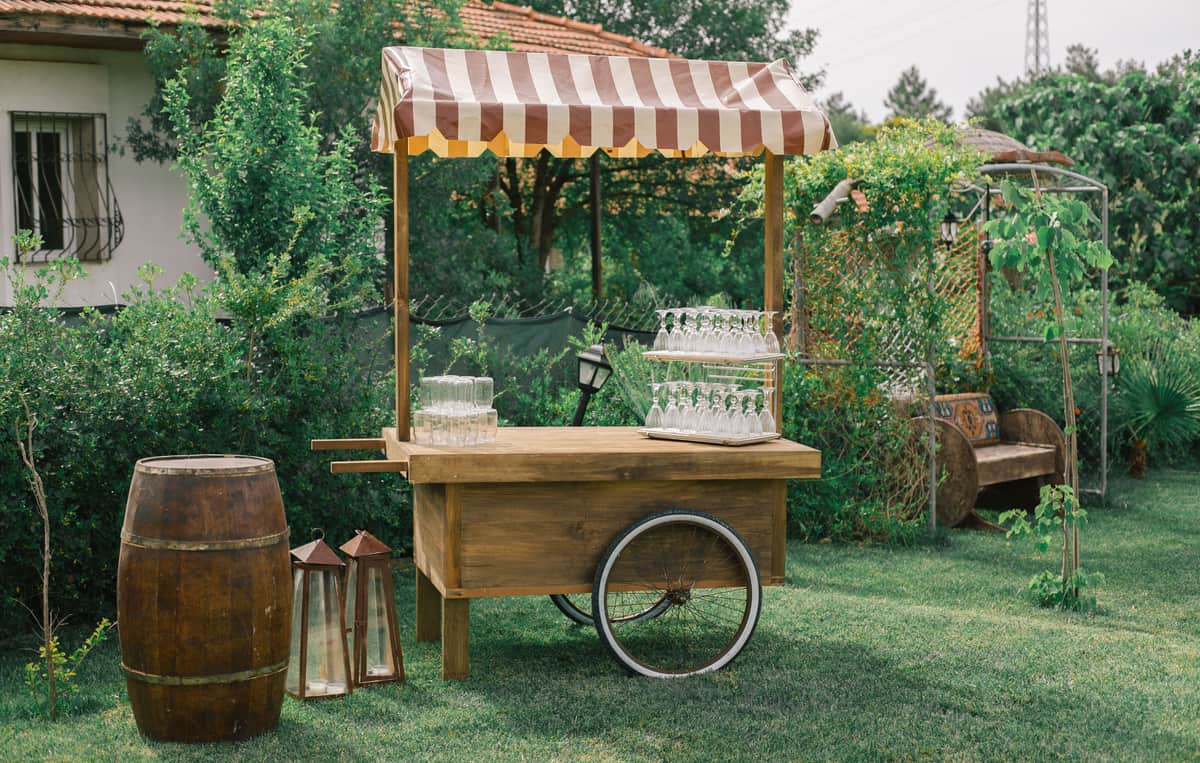 A wooden tea trolley with a lipped tray top standing in a hallway