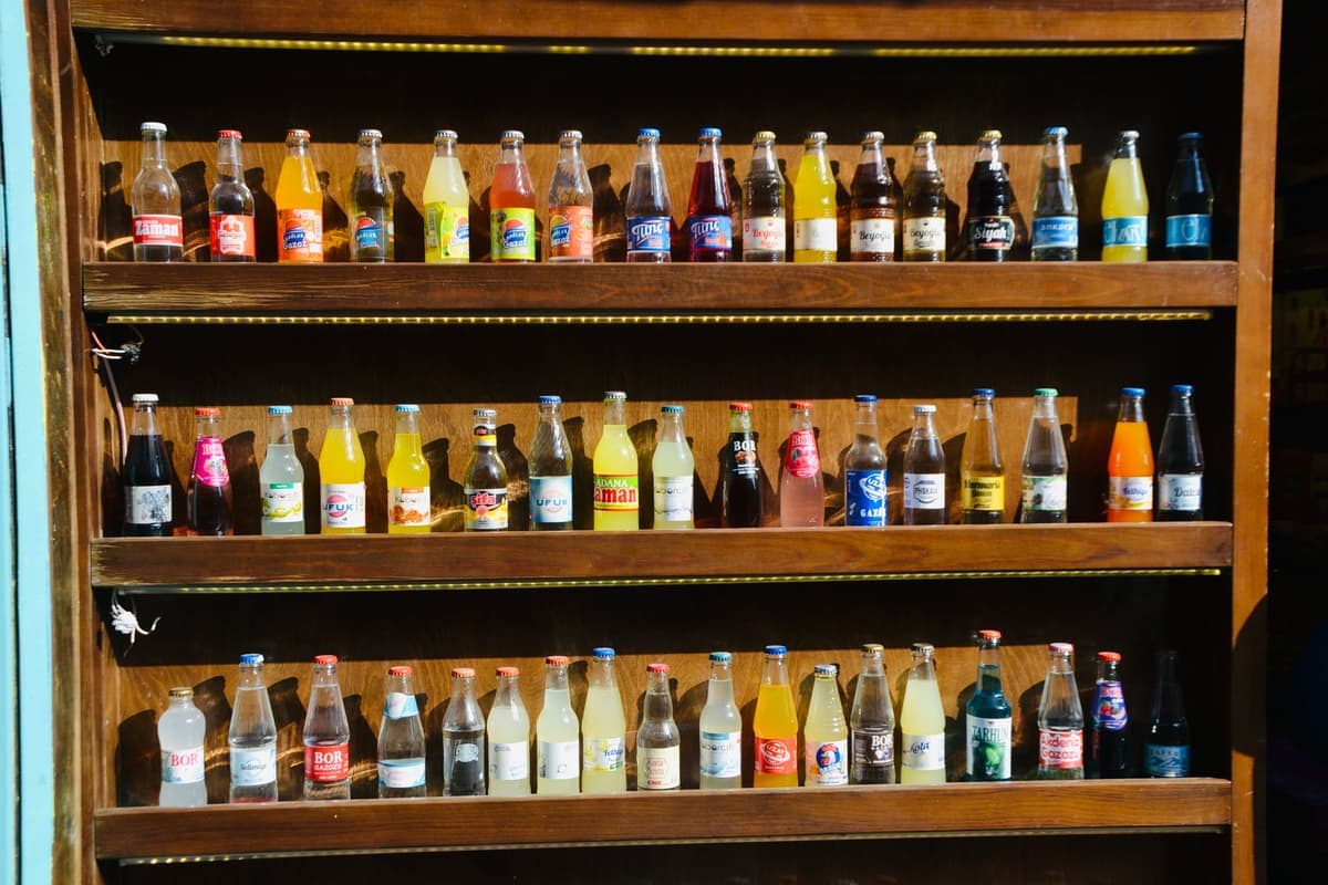 Several full glass bottles standing together on a shelf