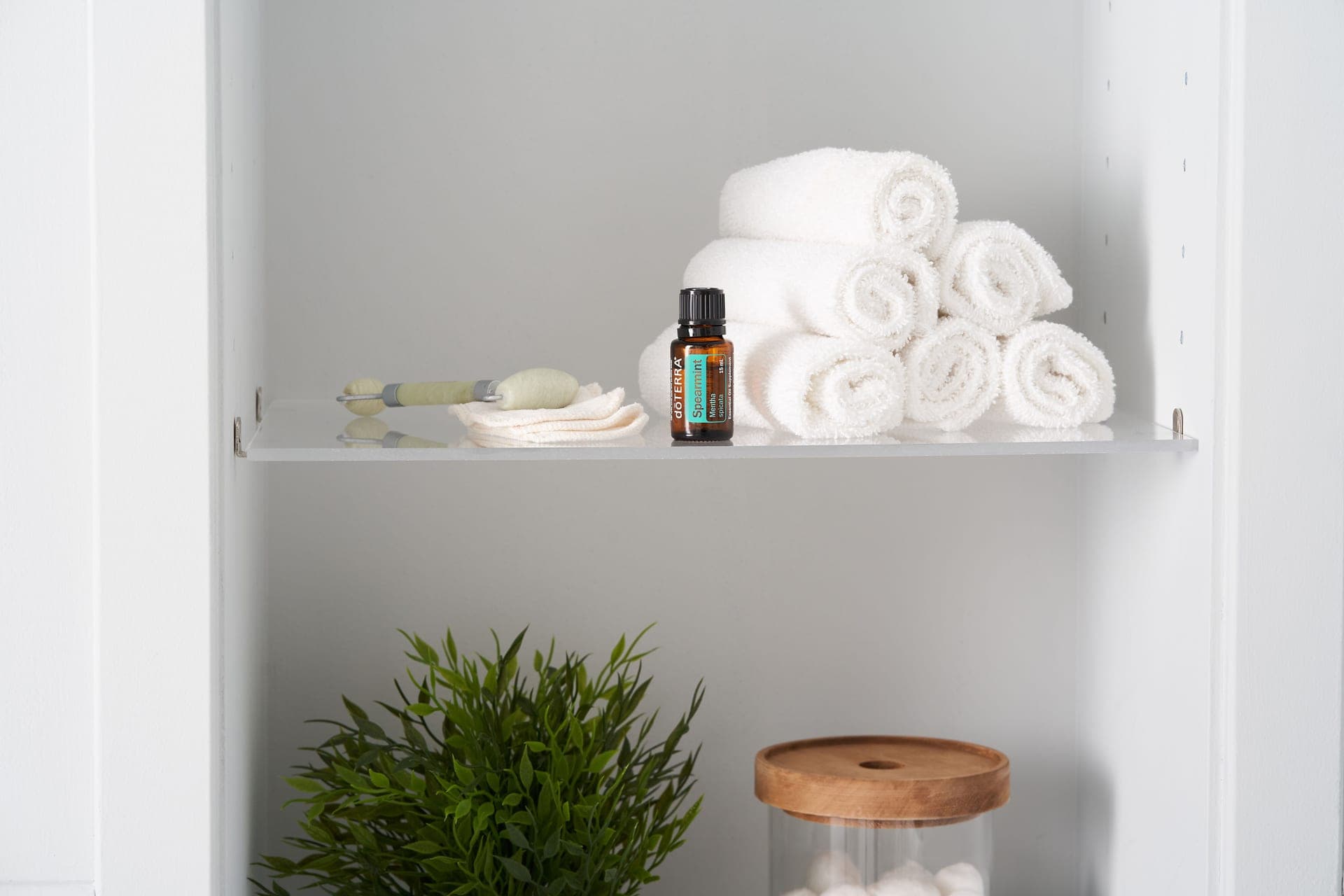 Neatly folded towels and small bottles arranged on a shelf in a spa-like setting