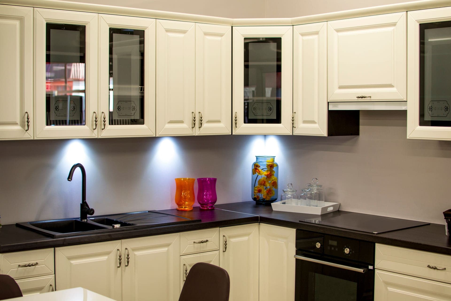 A modern kitchen with white closed cabinets and a few decorative pieces