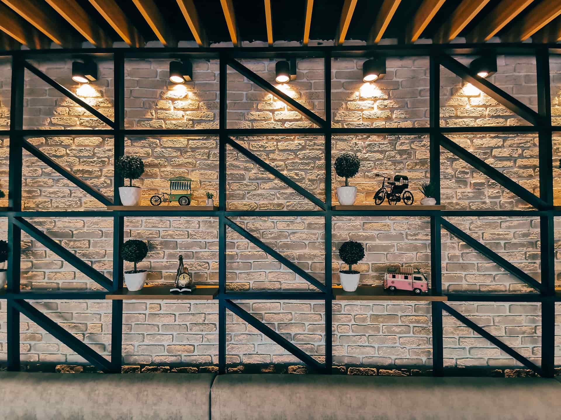 Two runs of shelving against a brick wall under warm lighting
