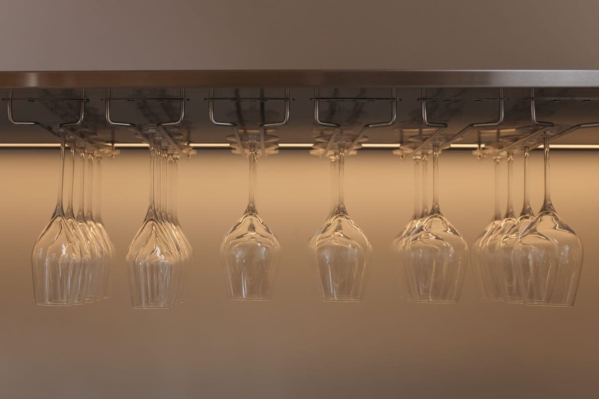 Wine glasses hanging upside down from a wooden rack