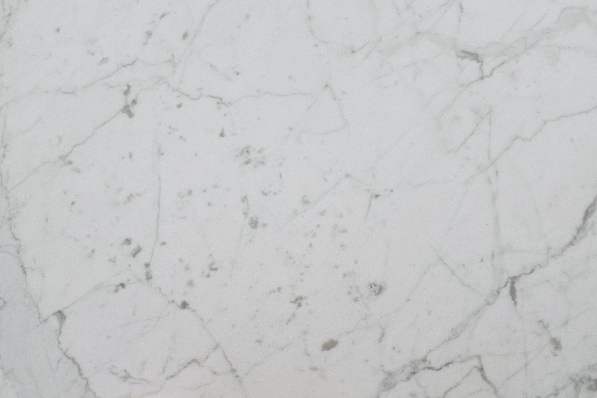 A white marble surface photographed close up, showing natural grey veining