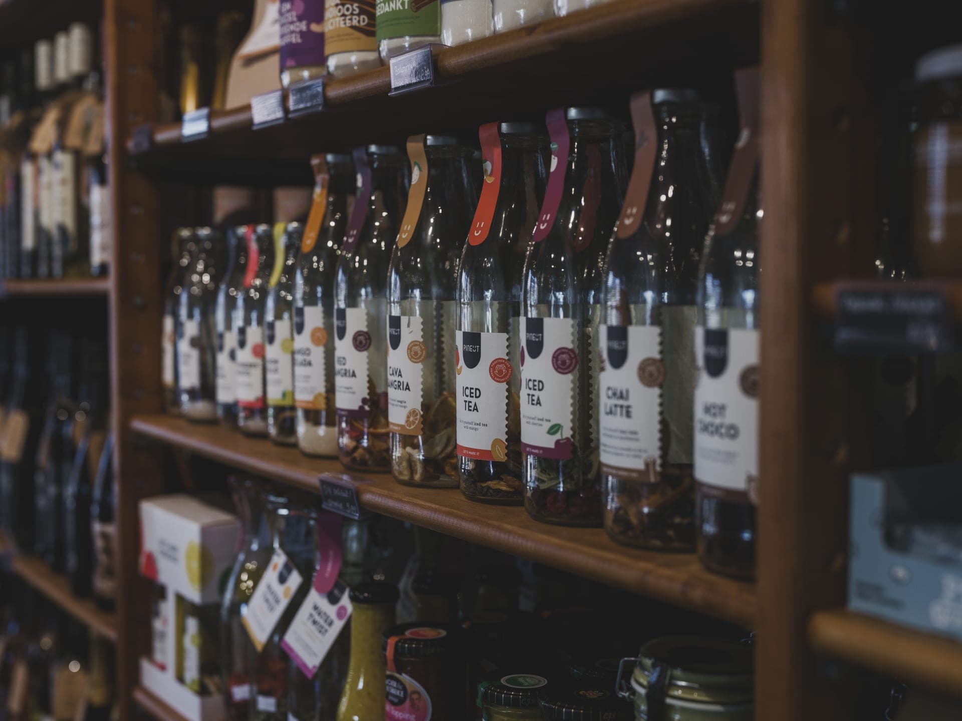 Bottled drinks lined up along long wooden shelves