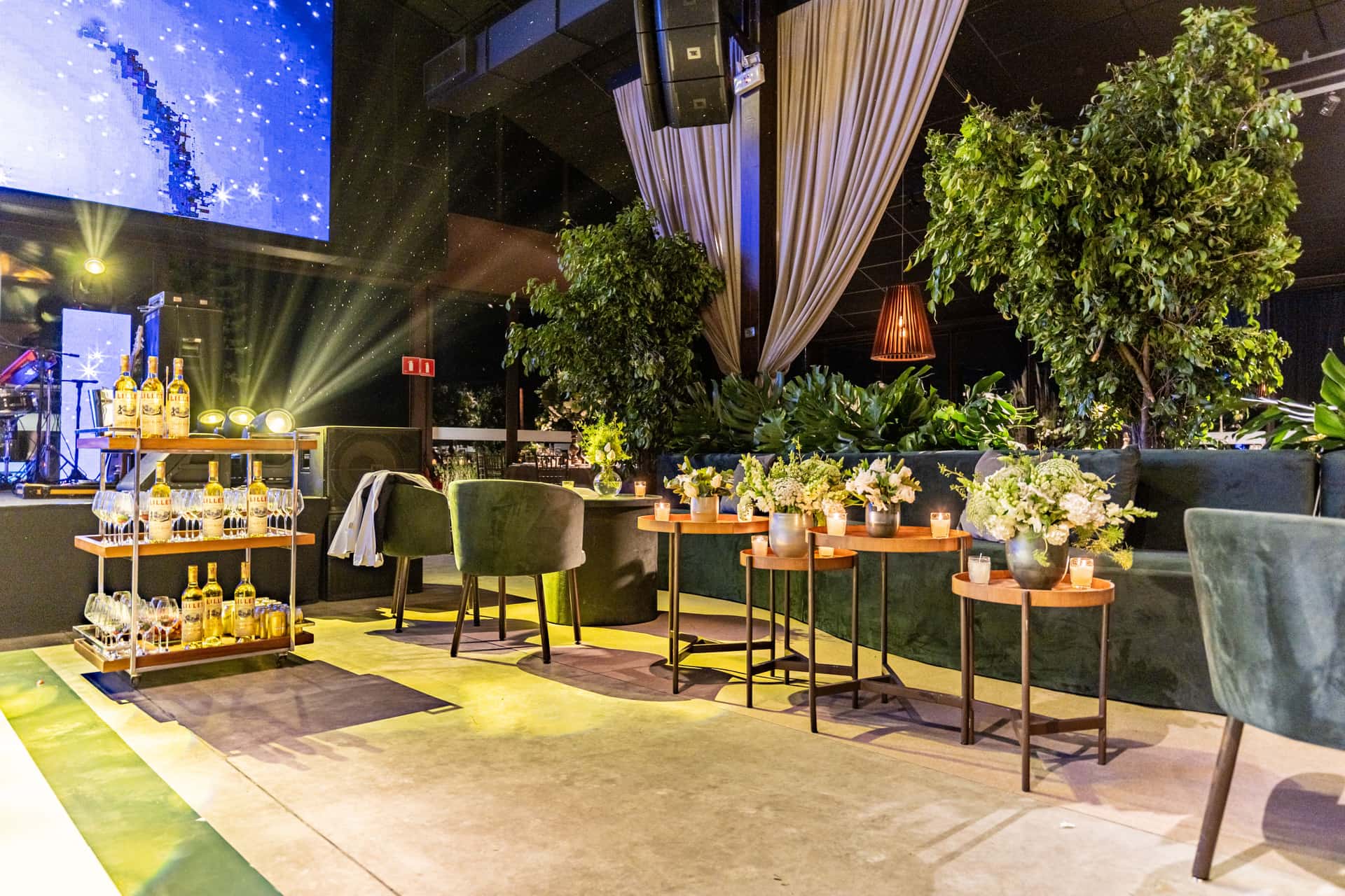 An indoor venue with a bar cart, plants and seating