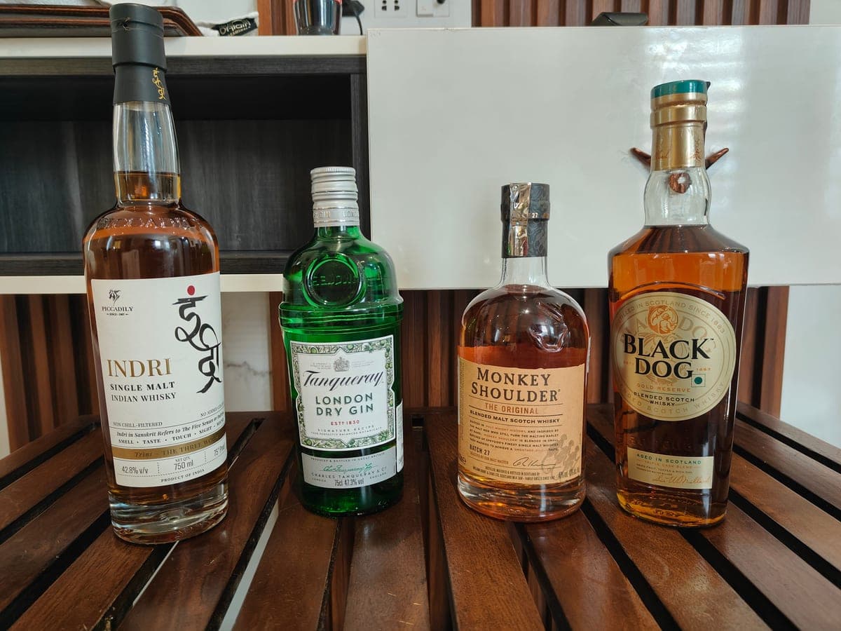 Several spirits bottles standing in a row on a wooden surface