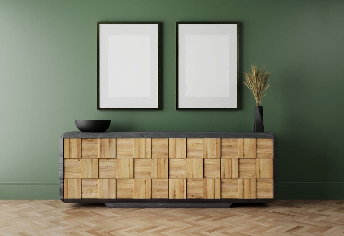 A framed print hanging on a wall above a low piece of furniture