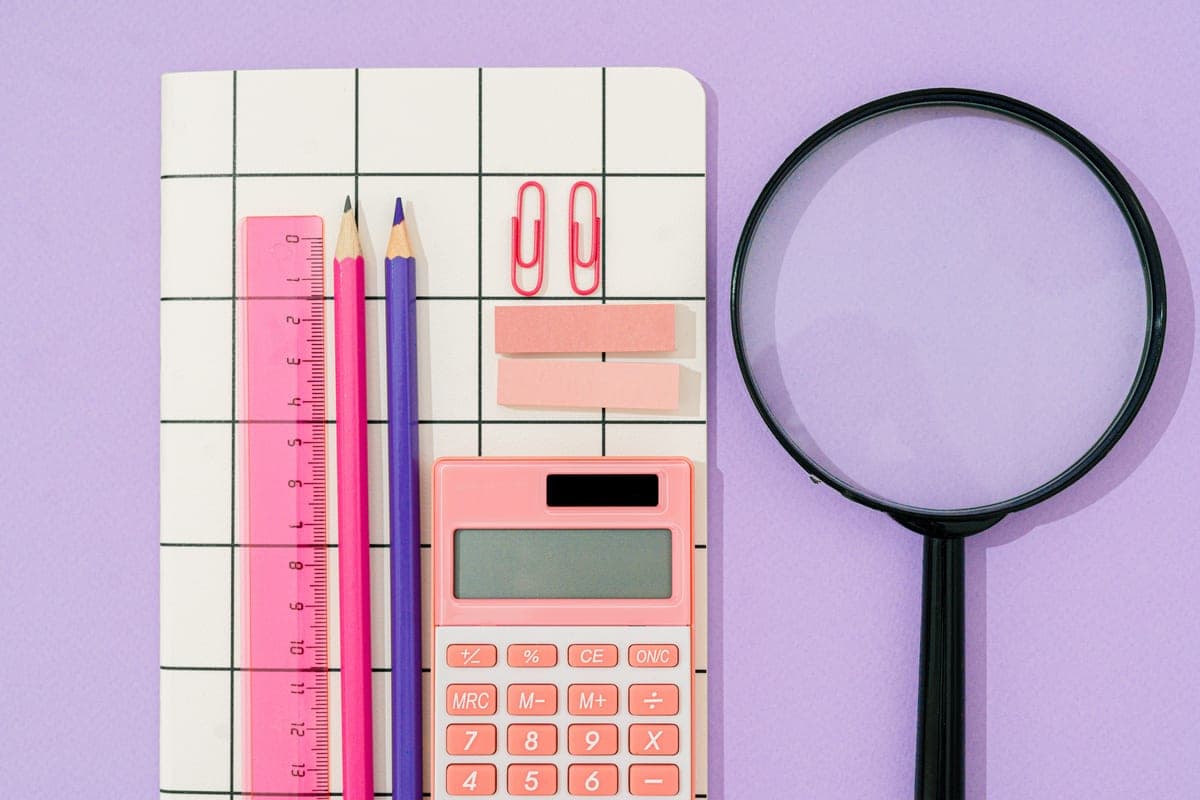 A notebook, a calculator and a tape measure on a work surface